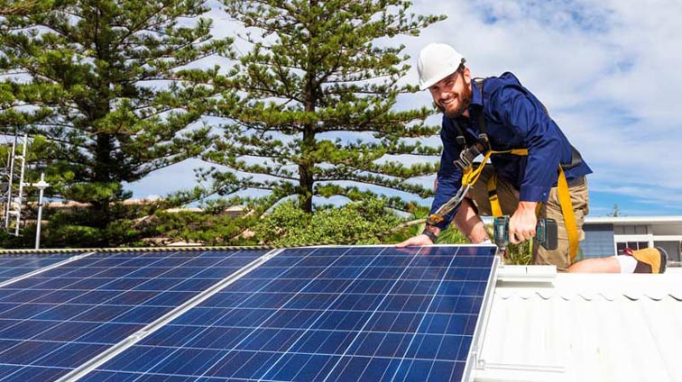 Instalador colocando placas solares en viviendas para autoconsumo en España